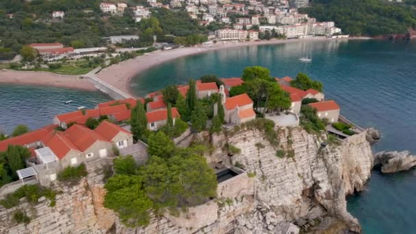 Luchtfoto 's. Slowmotion video van het eiland Sveti Stefan. Beroemde toeristische locatie in de buurt van de stad Budva. Reizen naar Montenegro — Stockvideo