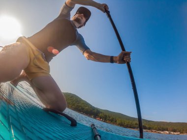 Stand-Up Paddle tahtasındaki çekici adam, SUP