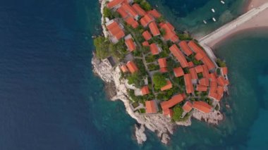 Hava görüntüsü. Sveti Stefan adasının yavaş çekim videosu. Budva şehrinin yakınlarında ünlü bir turistik mekan. Karadağ 'a Seyahat