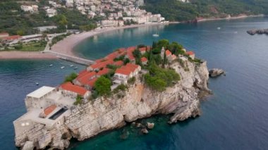 Hava görüntüsü. Sveti Stefan adasının yavaş çekim videosu. Budva şehrinin yakınlarında ünlü bir turistik mekan. Karadağ 'a Seyahat