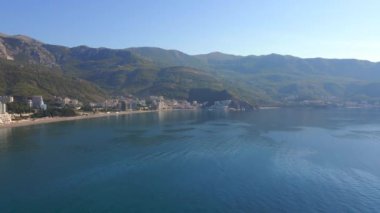 Yavaş çekim hava görüntüsü. Budva kenti, Karadağ 'da popüler bir turizm merkezi olan Bechichi veya Becici plajı manzaralı