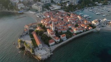Hava videosu. Yavaş çekim yap. Budva 'nın Eski Kenti Karadağ' da popüler bir turizm beldesi. Gün batımı zamanı.