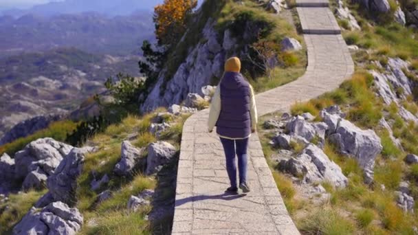 Genç bir kadın gezgin Lovcen dağının tepesindeki manzara noktasını ziyaret eder. Petar II Petroviç-Njegos Anıtmezarı — Stok video