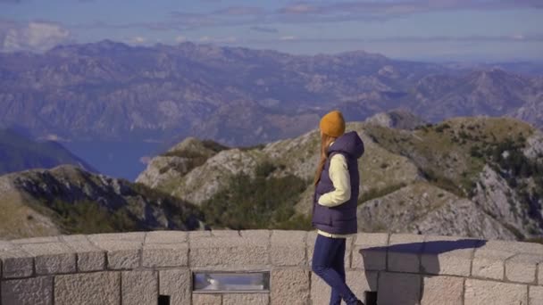 Une jeune voyageuse visite le point de vue sur le sommet de la montagne Lovcen. Le mausolée de Petar II Petrovic-Njegos — Video