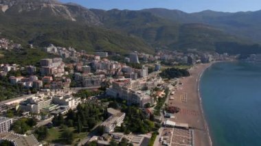 Yavaş çekim hava görüntüsü. Budva kenti, Karadağ 'da popüler bir turizm merkezi olan Bechichi veya Becici plajı manzaralı
