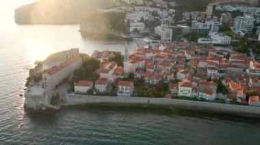 Hava videosu. Yavaş çekim yap. Budva 'nın Eski Kenti Karadağ' da popüler bir turizm beldesi. Gün batımı zamanı.