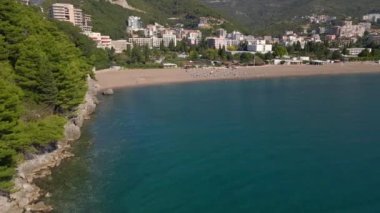 Yavaş çekim hava görüntüsü. Budva kenti, Karadağ 'da popüler bir turizm merkezi olan Bechichi veya Becici plajı manzaralı