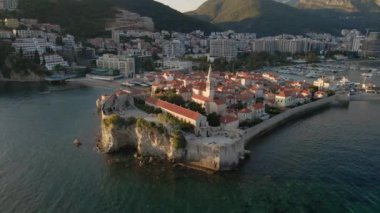 Hava videosu. Yavaş çekim yap. Budva 'nın Eski Kenti Karadağ' da popüler bir turizm beldesi. Gün batımı zamanı.