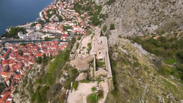 Foto aérea de la fortaleza San Juan San Giovanni sobre el casco antiguo de Kotor, el famoso lugar turístico de Montenegro. — Vídeo de stock