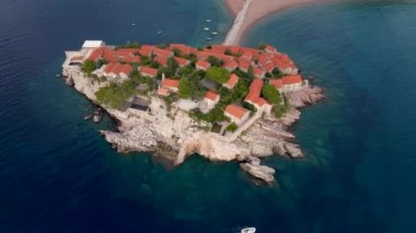 Hava görüntüsü. Sveti Stefan adasının yavaş çekim videosu. Budva şehrinin yakınlarında ünlü bir turistik mekan. Karadağ 'a Seyahat