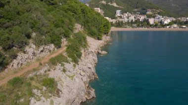 Yavaş çekim hava görüntüsü. Budva şehri, Budva ile Bechichi plajı arasındaki kayanın manzarası.