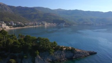 Yavaş çekim hava görüntüsü. Budva kenti, Karadağ 'da popüler bir turizm merkezi olan Bechichi veya Becici plajı manzaralı