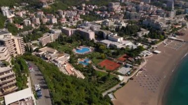 Yavaş çekim hava görüntüsü. Budva kenti, Karadağ 'da popüler bir turizm merkezi olan Bechichi veya Becici plajı manzaralı