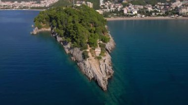 Yavaş çekim hava görüntüsü. Budva kenti, Karadağ 'da popüler bir turizm merkezi olan Bechichi veya Becici plajı manzaralı