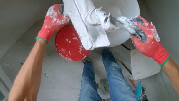 POV lövés. Egy férfi mester festő vakolja a falat. — Stock videók
