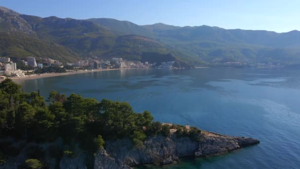 Vídeo aéreo em câmara lenta. A cidade de Budva, vista para a praia de Bechichi ou Becici, um lugar turístico popular em Montenegro — Vídeo de Stock