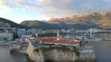 Hava videosu. Yavaş çekim yap. Budva 'nın Eski Kenti Karadağ' da popüler bir turizm beldesi. Gün batımı zamanı.