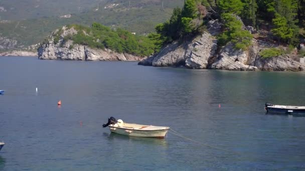Kleine boten in een neen in de buurt van het eiland Sveti Stefan. Beroemde toeristische locatie in de buurt van de stad Budva. Reizen naar Montenegro — Stockvideo