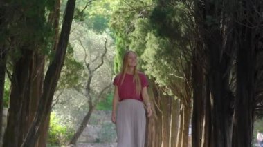 Budva kenti yakınlarındaki Park Milocer 'de vadi boyunca yürüyen genç bir kadın turist. Karadağ 'a Seyahat