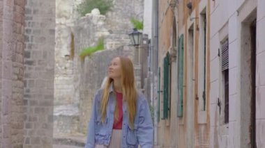 Karadağ 'ın Eski Kotor kentini ziyaret eden genç bir kadın görülüyor. Karadağ 'a seyahat. Bir dünya mirası alanı. El kamerasıyla.