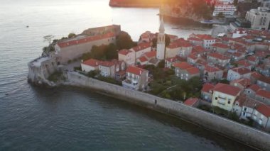 Hava videosu. Yavaş çekim yap. Budva 'nın Eski Kenti Karadağ' da popüler bir turizm beldesi. Gün batımı zamanı.