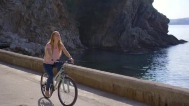 Karadağ 'ın ünlü bir turizm merkezi olan Budva' da bisiklet süren genç bir kadın görülüyor. Karadağ 'a Seyahat