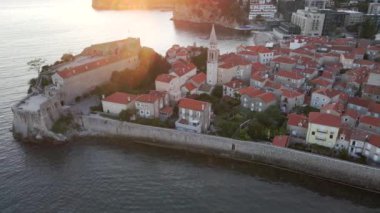 Hava videosu. Yavaş çekim yap. Budva 'nın Eski Kenti Karadağ' da popüler bir turizm beldesi. Gün batımı zamanı.