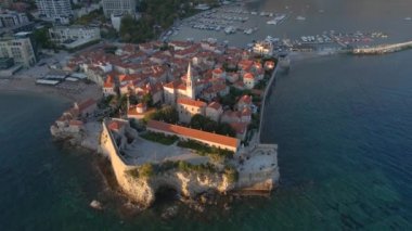 Hava videosu. Yavaş çekim yap. Budva 'nın Eski Kenti Karadağ' da popüler bir turizm beldesi. Gün batımı zamanı.