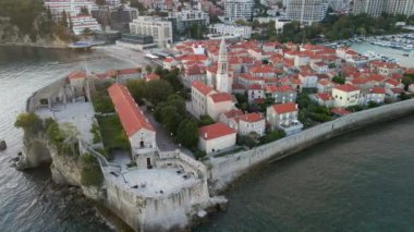 Hava videosu. Yavaş çekim yap. Budva 'nın Eski Kenti Karadağ' da popüler bir turizm beldesi. Gün batımı zamanı.