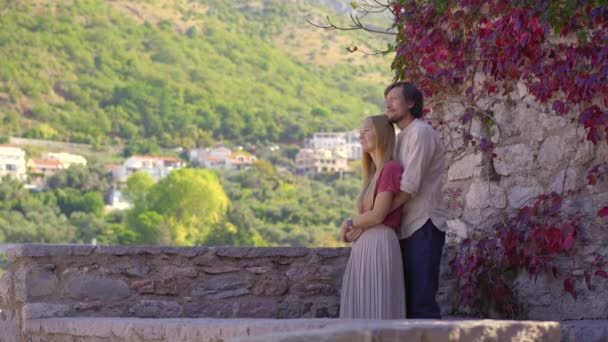 Egy férfi és egy nő utazó látogatja meg a Sveti Stefan szigetet. Híres turisztikai helyen, közel a város Budva. Utazás Montenegróba koncepció. — Stock videók