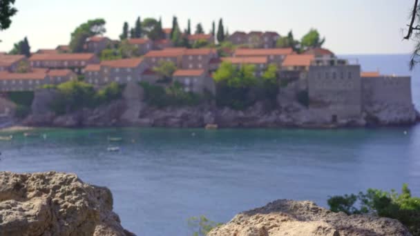 A man traveler visits the Sveti Stefan island. Famous tourist location near the city of Budva. Travel to Montenegro concept. Handheld shot — Stock video