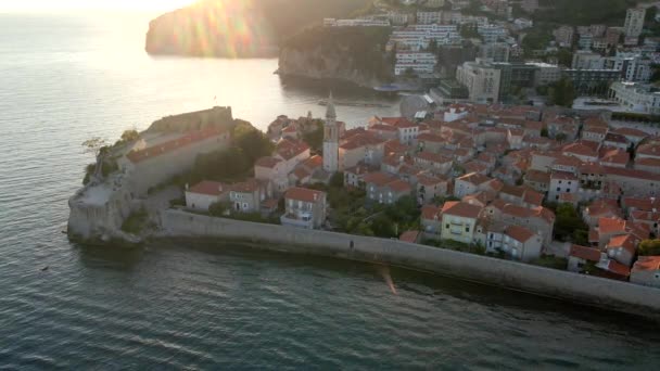 Aerial video. Slowmotion shot. The Old Town of the city of Budva popular tourist destination in Montenegro. Sunset time. — Stockvideo