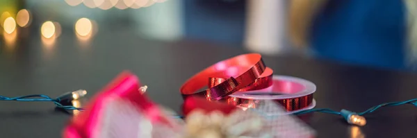 La joven está empacando regalos. Presentado envuelto en papel artesanal con una cinta roja y dorada para Navidad, cumpleaños, día de la madre o San Valentín BANNER, FORMATO LARGO — Foto de Stock