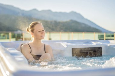 Genç kaygısız mutlu kadının portresi jakuzide rahatlayarak yeşil büyük dağların arka planında mutlu bir tatil hayatı yaşıyor.
