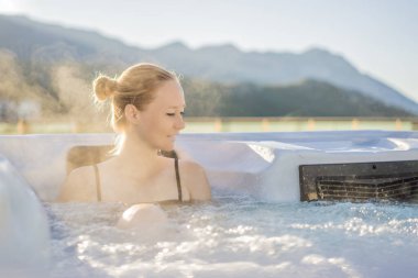 Genç kaygısız mutlu kadının portresi jakuzide rahatlayarak yeşil büyük dağların arka planında mutlu bir tatil hayatı yaşıyor.