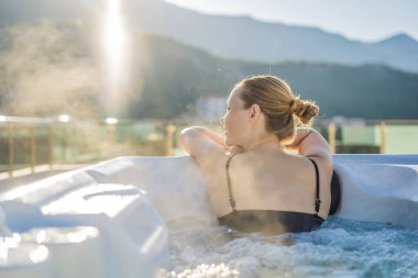 Genç kaygısız mutlu kadının portresi jakuzide rahatlayarak yeşil büyük dağların arka planında mutlu bir tatil hayatı yaşıyor.