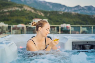 Genç kaygısız mutlu kadının portresi jakuzide rahatlayarak yeşil büyük dağların arka planında mutlu bir tatil hayatı yaşıyor.