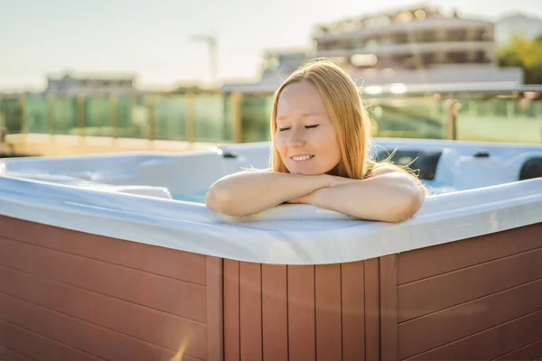 Retrato de la joven despreocupada feliz mujer sonriente relajarse en la bañera de hidromasaje durante el disfrute de la vida feliz viaje momento de vacaciones en el fondo de grandes montañas verdes — Foto de Stock