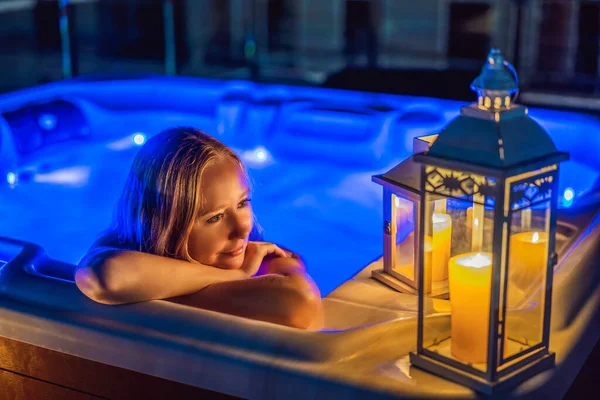 Retrato de la joven mujer sonriente feliz y despreocupada que se relaja en la bañera de hidromasaje por la noche durante las felices vacaciones del momento de viaje. La vida en el fondo de grandes montañas verdes — Foto de Stock