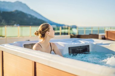 Genç kaygısız mutlu kadının portresi jakuzide rahatlayarak yeşil büyük dağların arka planında mutlu bir tatil hayatı yaşıyor.