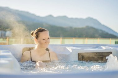 Genç kaygısız mutlu kadının portresi jakuzide rahatlayarak yeşil büyük dağların arka planında mutlu bir tatil hayatı yaşıyor.