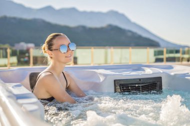 Genç kaygısız mutlu kadının portresi jakuzide rahatlayarak yeşil büyük dağların arka planında mutlu bir tatil hayatı yaşıyor.