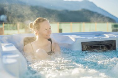 Genç kaygısız mutlu kadının portresi jakuzide rahatlayarak yeşil büyük dağların arka planında mutlu bir tatil hayatı yaşıyor.