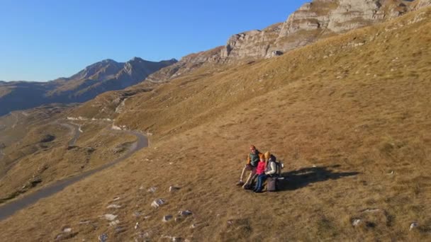 Luchtfoto 's. Familie van toeristen bezoekt de Sedlo pas, Bobov Kuk in de bergen van het noorden van Montenegro. Ze zitten op een bank. Neergeschoten in de herfst — Stockvideo