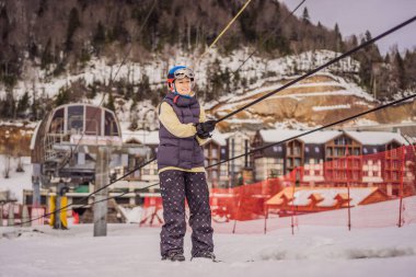 Kadın kayakçı yeni başlayanlar için kayak asansörüyle dağa tırmanır.