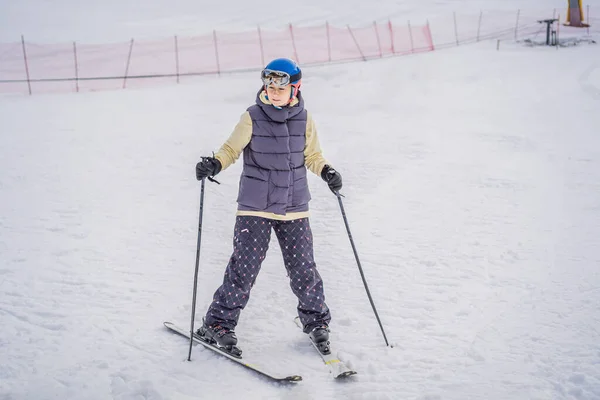 Γυναίκα μαθαίνει σκι. Νεαρή γυναίκα που κάνει σκι σε ένα χιονισμένο δρόμο στα βουνά — Φωτογραφία Αρχείου