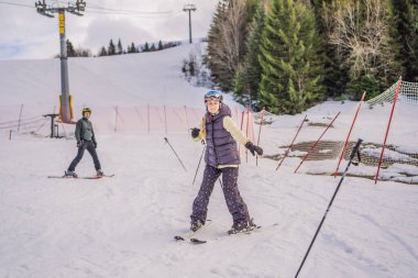 Kadın, hocasıyla kayak yapmayı öğreniyor. Kış sporu. Alp okulunda kayak dersi