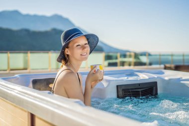 Genç kaygısız mutlu kadının portresi jakuzide rahatlayarak yeşil büyük dağların arka planında mutlu bir tatil hayatı yaşıyor.