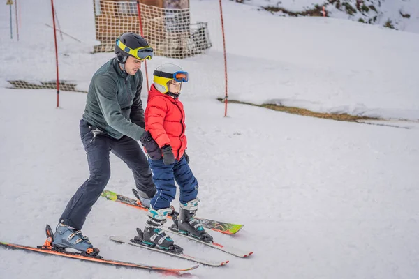 Boy learning to ski, training and listening to his ski instructor on the slope in winter — Stock Photo, Image