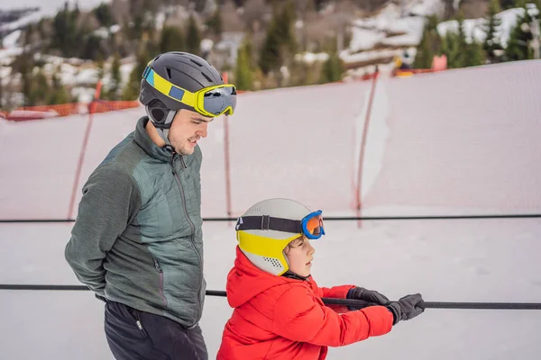 Instruktor uczy chłopca jeździć na nartach na wyciągu — Zdjęcie stockowe